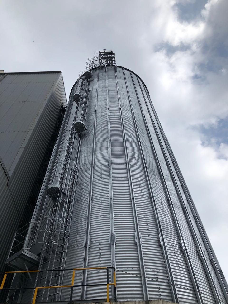 Steel grain silo against clouds