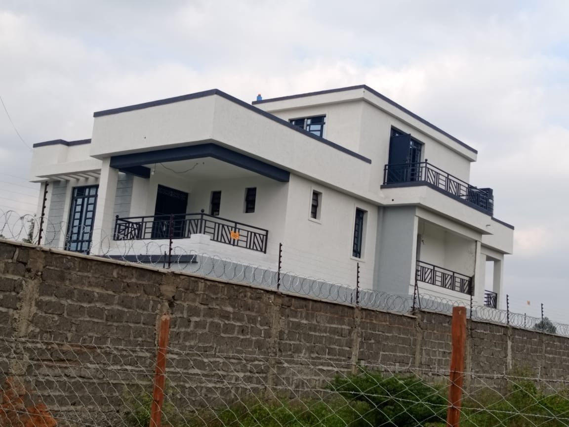 Navy and white villa behind stone wall
